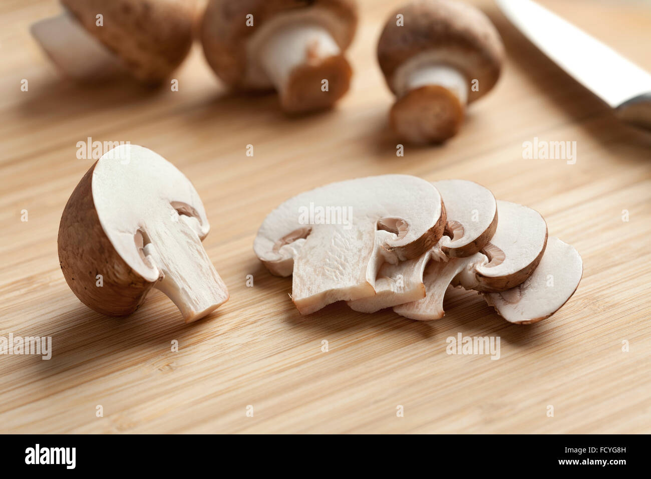 Castagne fresche fette di funghi sul bordo di taglio Foto Stock