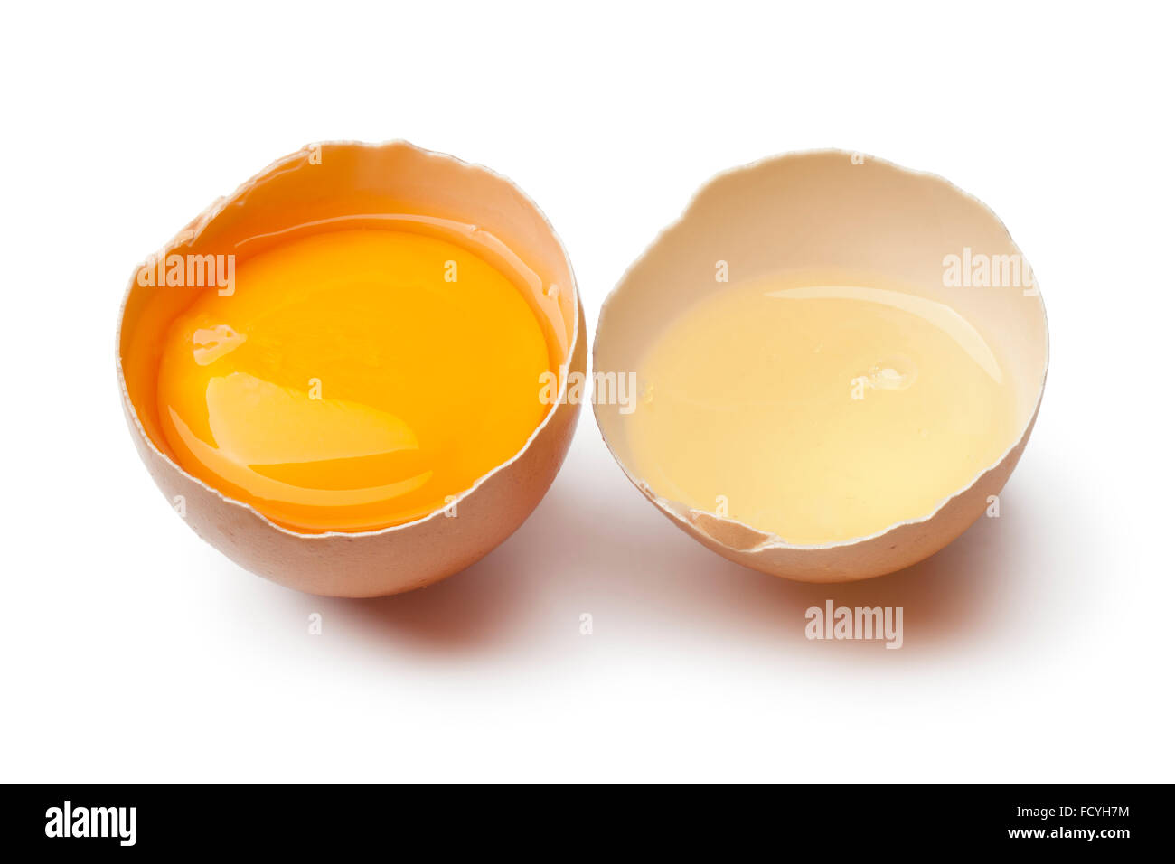 Tuorlo d'uovo e bianco in un marrone rotto il guscio delle uova su sfondo bianco Foto Stock