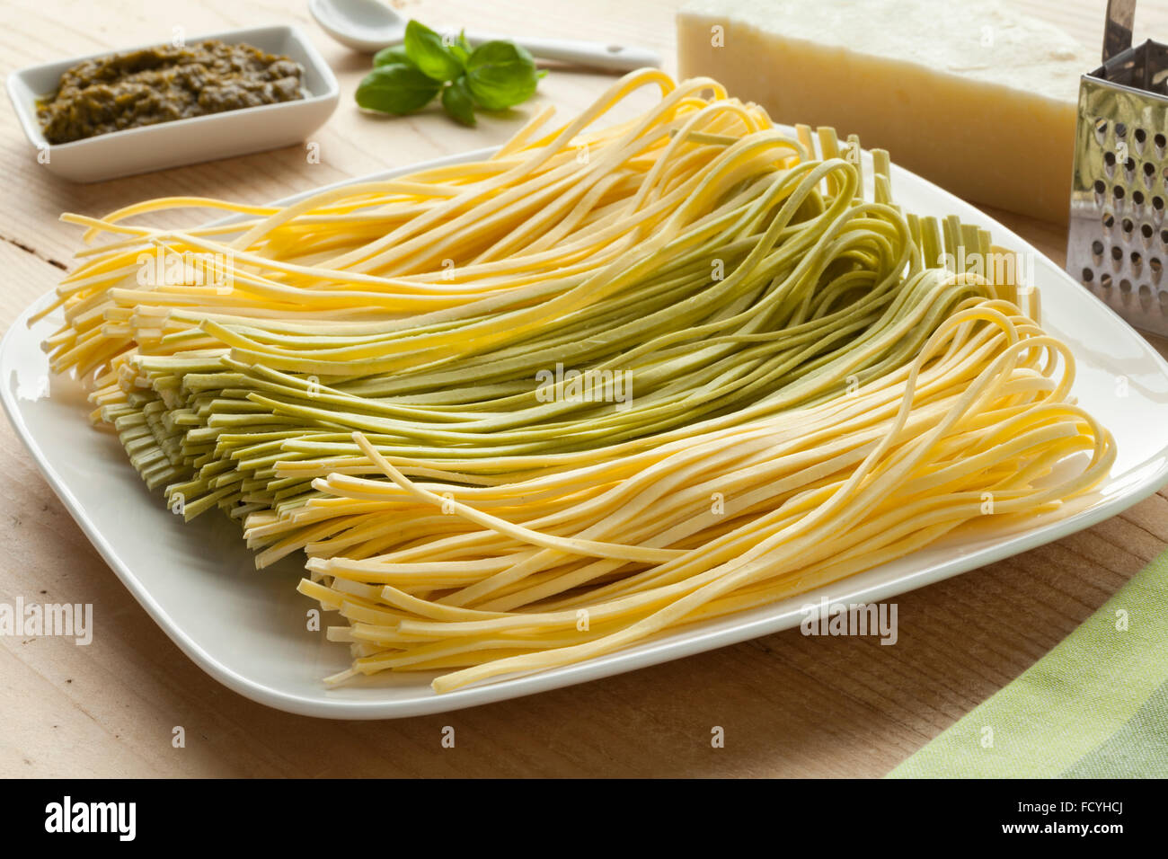 Tagliolini freschi bicolore su un piatto con il pesto,le foglie di basilico e pecorino Foto Stock