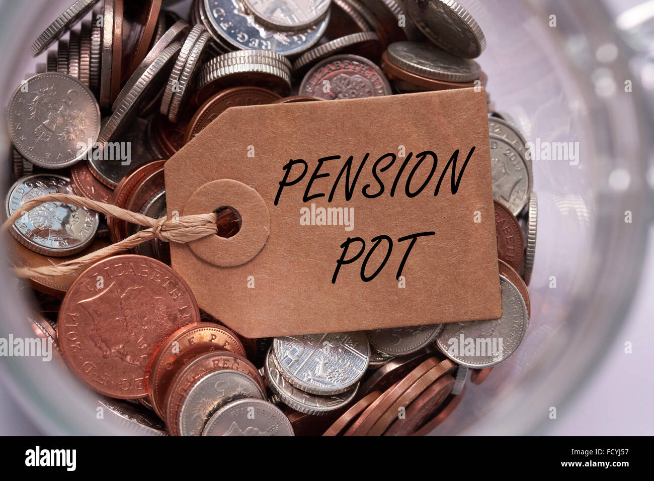 Pension pot etichetta sul british miscelati delle monete in euro all'interno di un vaso di vetro concetto concetto Foto Stock