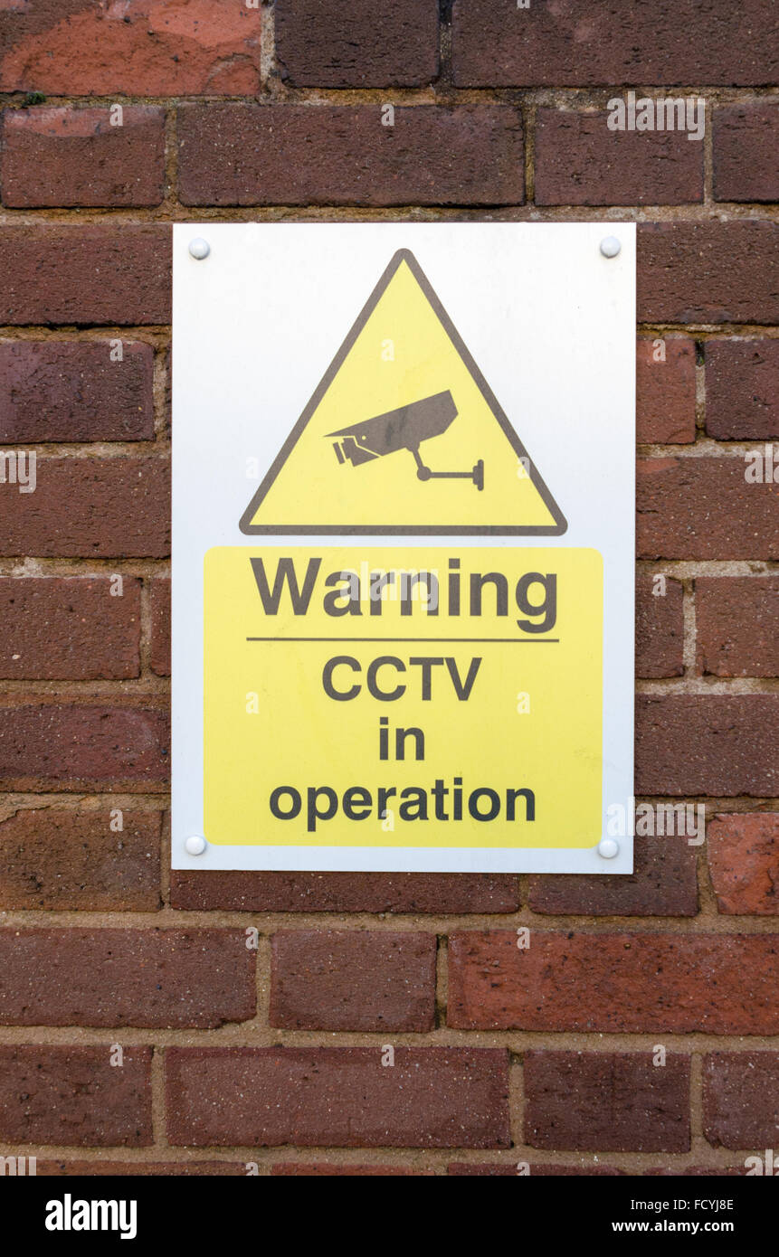 Segno di avvertimento CCTV in operazione su un muro di mattoni Foto Stock
