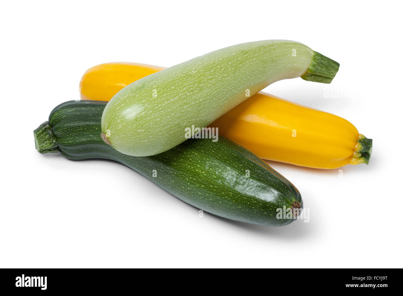 Crudo fresco zucchine in diversi colori su sfondo bianco Foto Stock