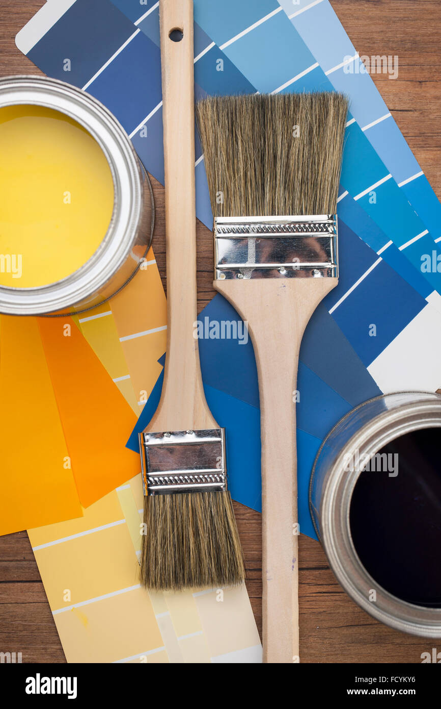 Elevato angolo di paint pots e schemi di colore con i pennelli in giallo e sfumature di blu Foto Stock