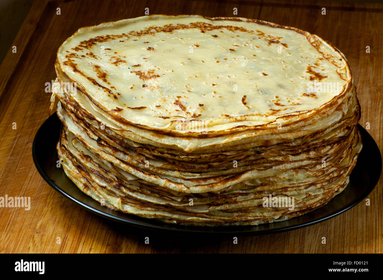 Pila di sottili frittelle russe sulla piastra nera Foto Stock