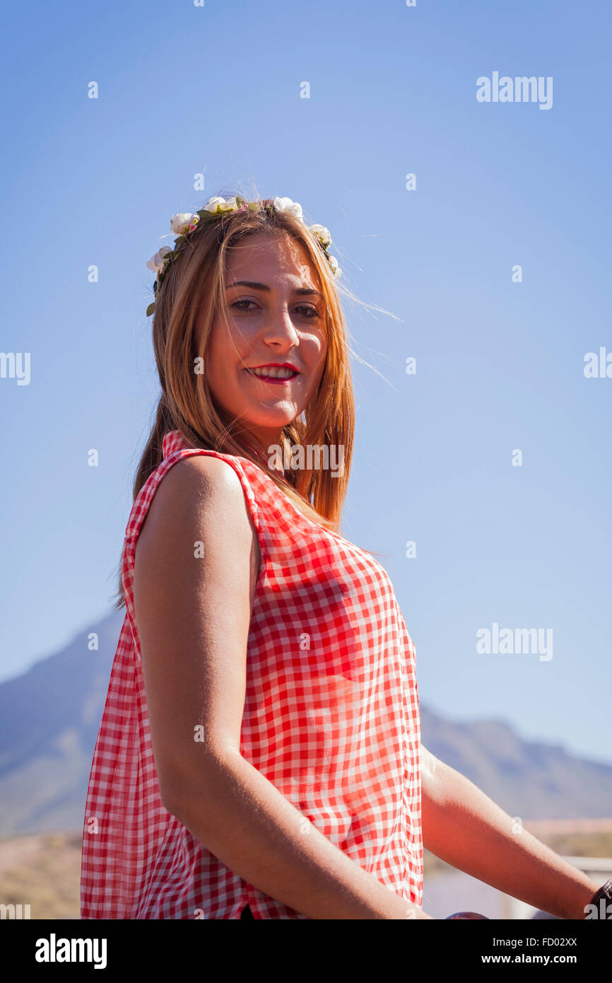 Donna pilota nel controllare la camicetta e fiori nei capelli al San Sebastian fiesta, La Caleta, Costa Adeje, Tenerife, Isole Canarie Foto Stock