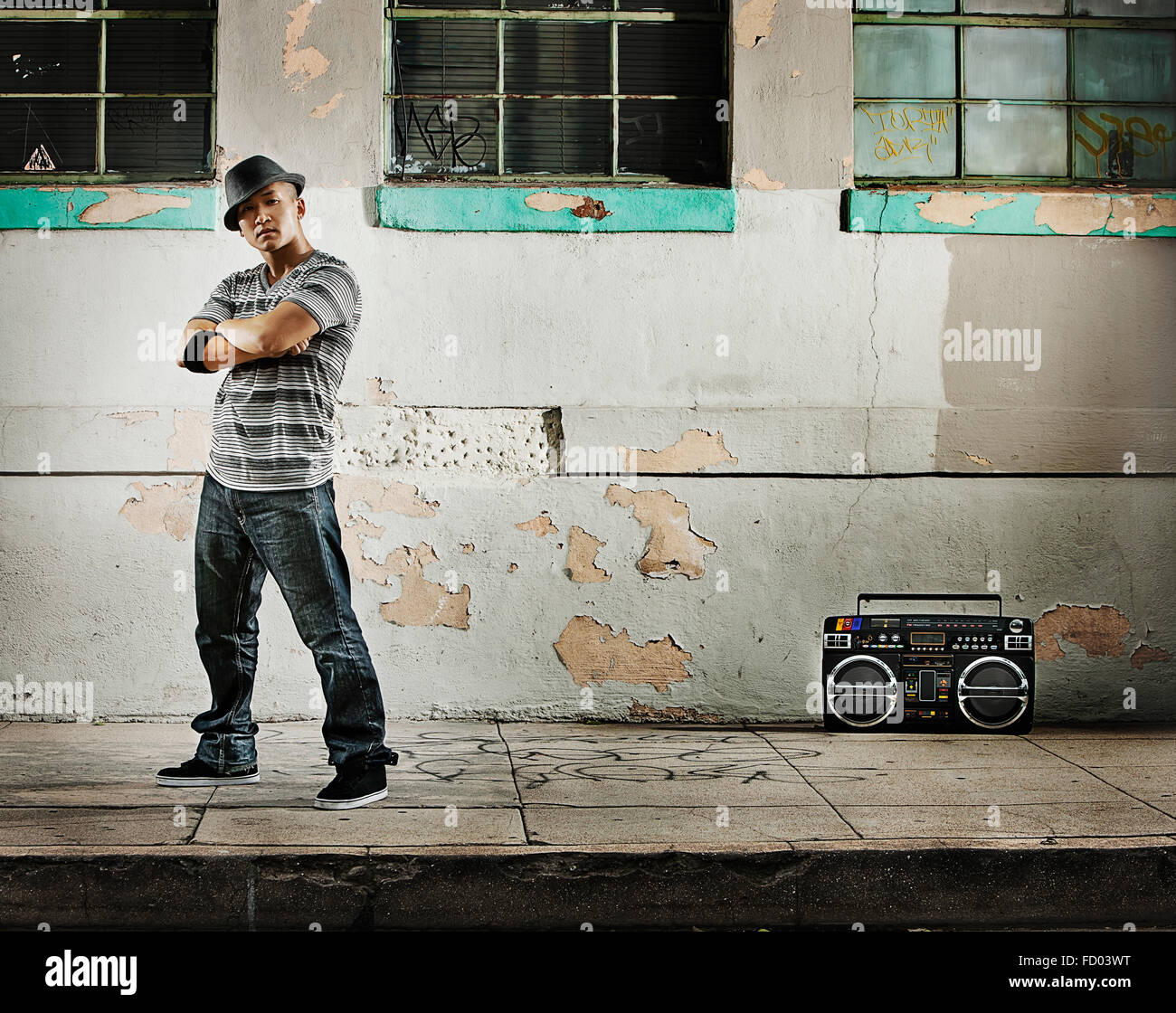 Un giovane uomo, un breakdancer esecutore con un boombox sulla strada di una città. Foto Stock