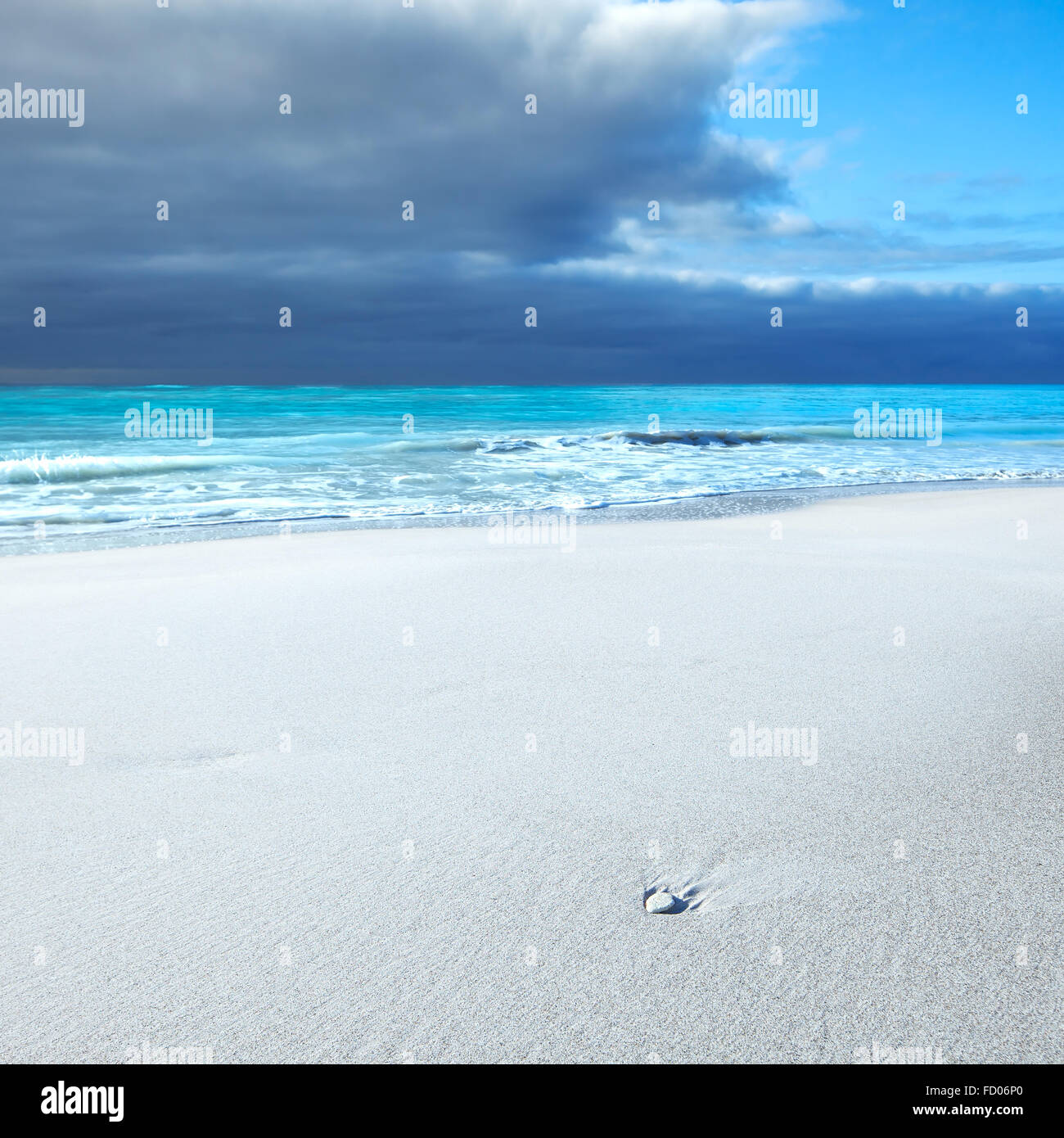 Oceano seascape. White rock o ciottolo in una spiaggia di sabbia bianca sotto il blu cielo molto nuvoloso in un cattivo tempo. Onde sullo sfondo. Foto Stock