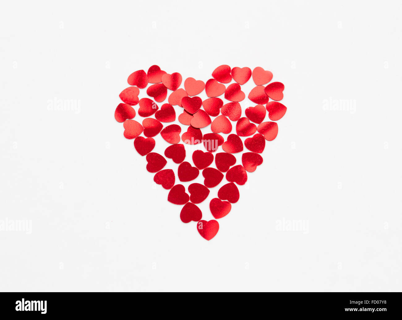 A forma di cuore isolato su un fondo bianco fatto da piccole forme di cuore. Foto Stock