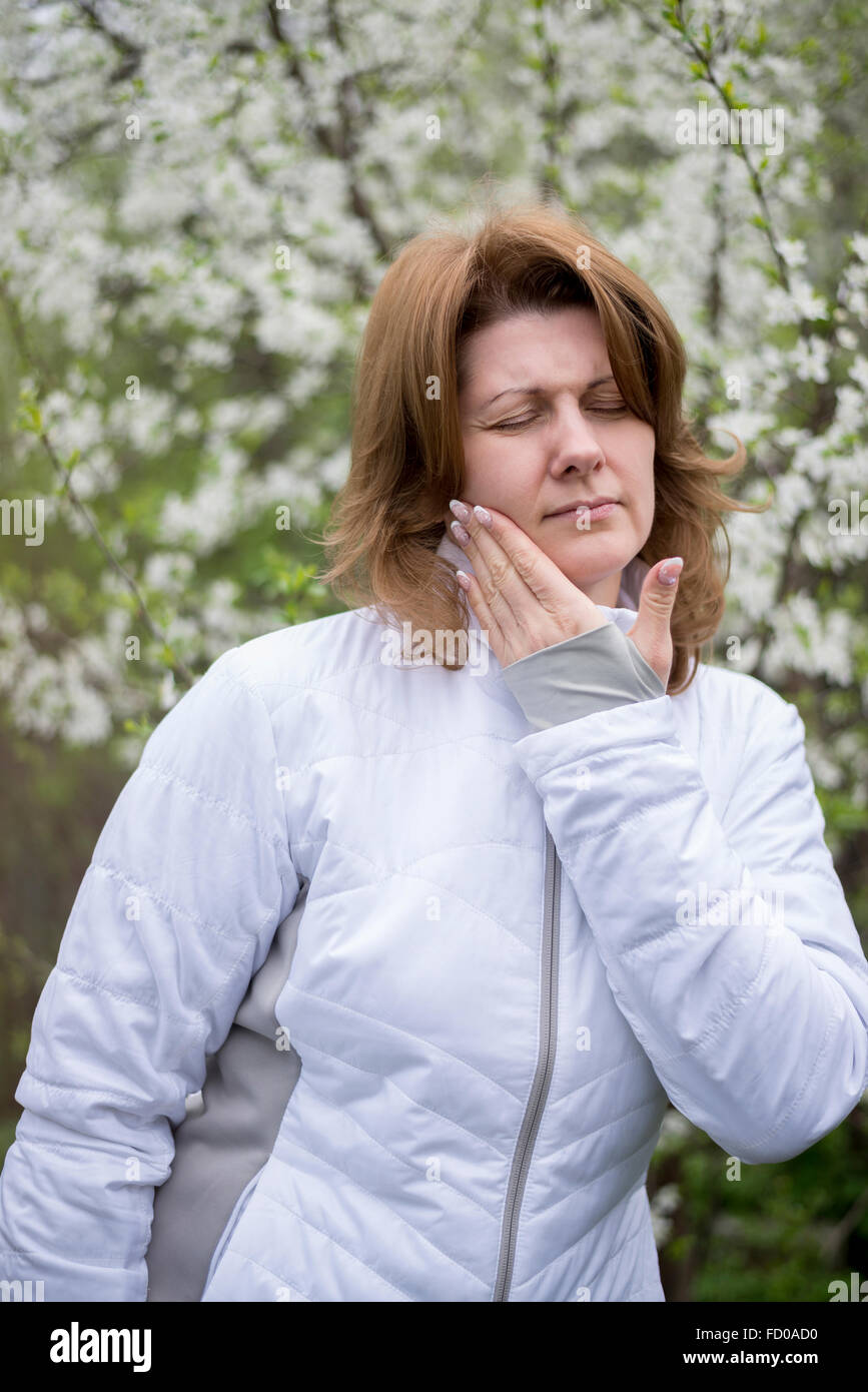 Una donna con il mal di denti sulla natura Foto Stock