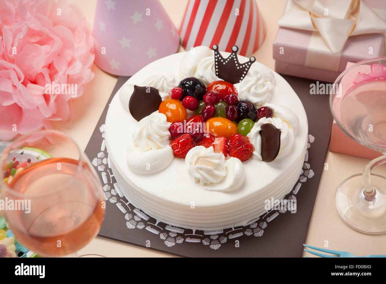 La torta di panna con frutti con molte decorazioni intorno ad esso Foto Stock