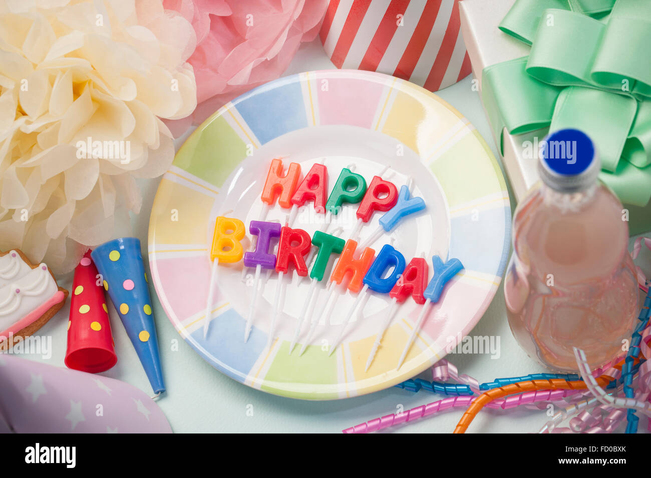 Elevato angolo di buon compleanno candele sulla piastra circondato da parte degli oggetti correlati Foto Stock