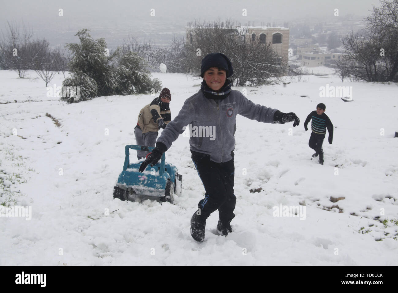 Hebron. 26 gen, 2016. Palestinesi giocare i bambini con una palla di neve durante una tempesta di neve in Cisgiordania città di Hebron, a gennaio 26, 2016. Tempesta condizioni meteo in tutta la regione hanno continuato come forti tempeste ha colpito la zona con neve e piogge torrenziali. © Mamoun Wazwaz/Xinhua/Alamy Live News Foto Stock