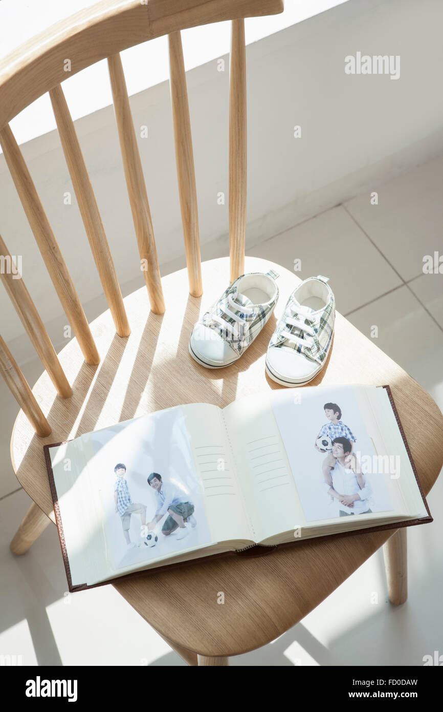 Elevato angolo di baby album e scarpe per bambini su una sedia Foto Stock