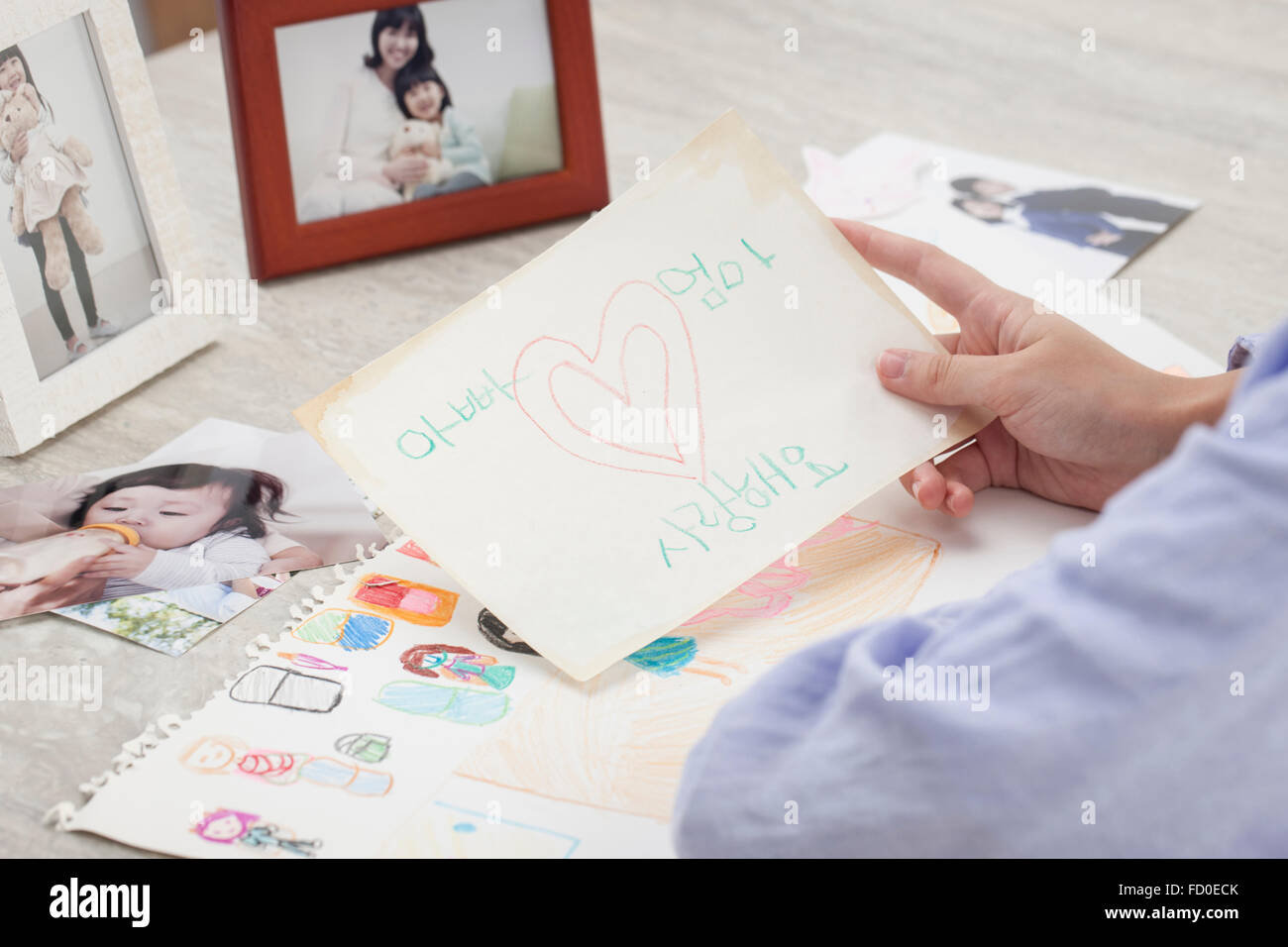 Card scritto da un bambino dicendo io amo il Padre e la madre detenute da una mano Foto Stock