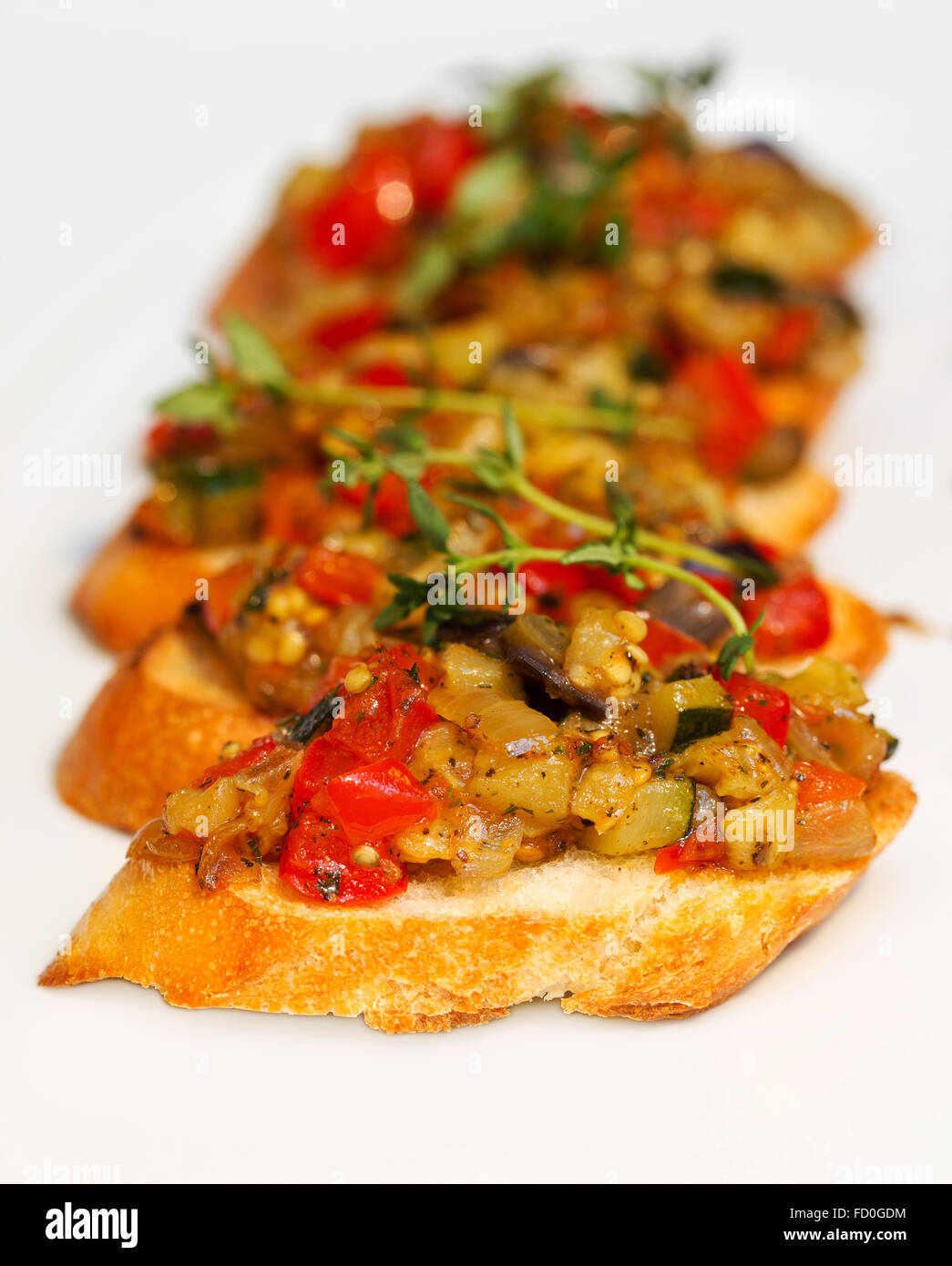 La bruschetta (Italiano tostato aglio pane) con legumi stufati, il fuoco selettivo. Cucina creativa. Foto Stock