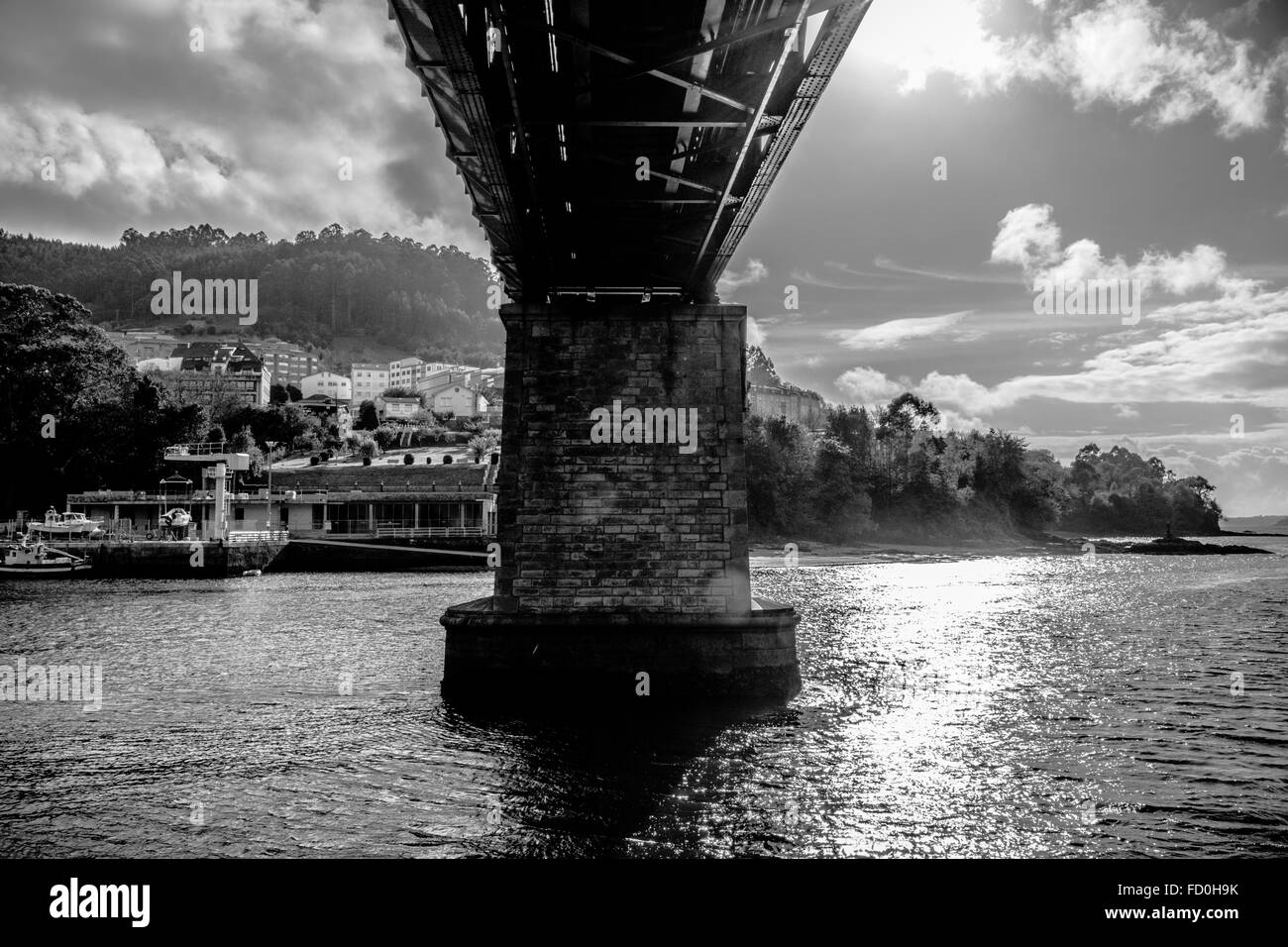 Basso Angolo di visione di un ponte ferroviario in un mare calmo da sotto le nuvole Foto Stock