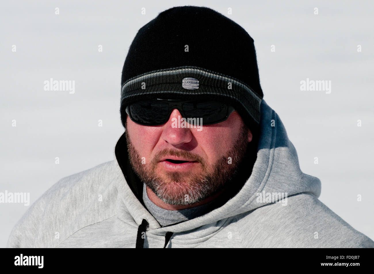Close-up di un grave alla ricerca di uomo di mezza età che indossa felpa nella neve Foto Stock