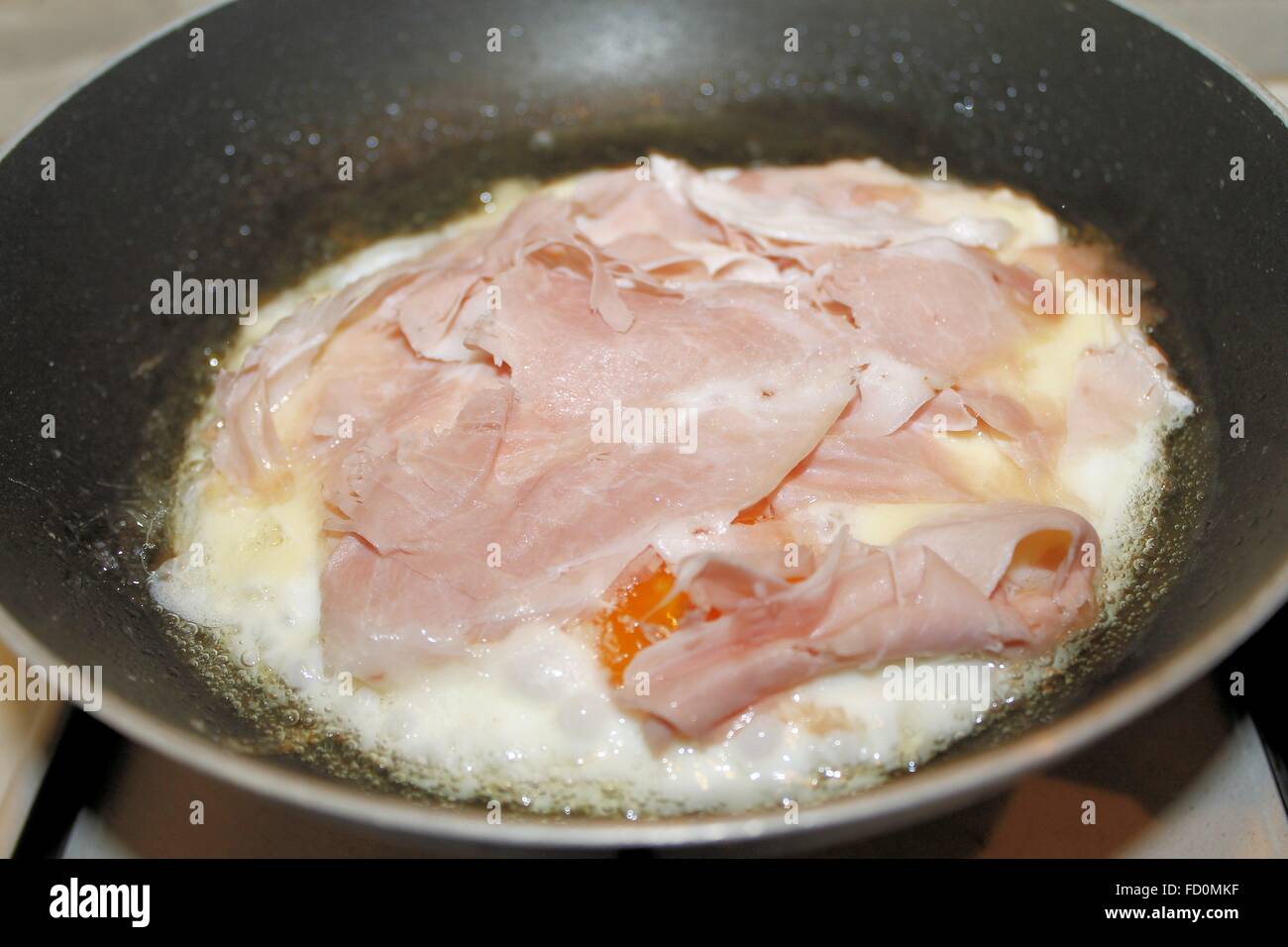 Piatto con uova fritte e prosciutto nel recipiente di cottura Foto Stock