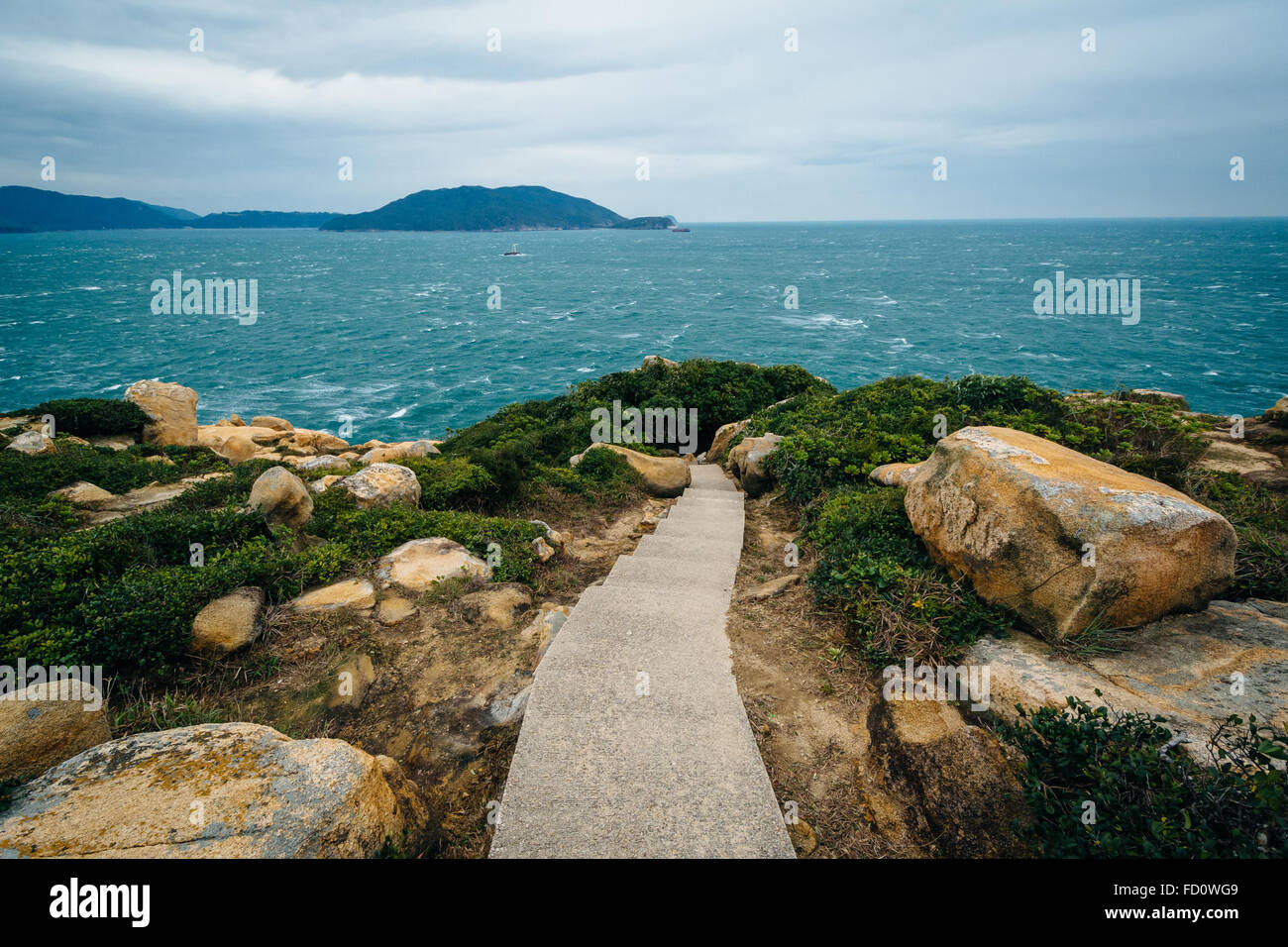 La passerella e la vista della costa a Tai Tau Chau, a Shek O, sull'Isola di Hong Kong, Hong Kong. Foto Stock