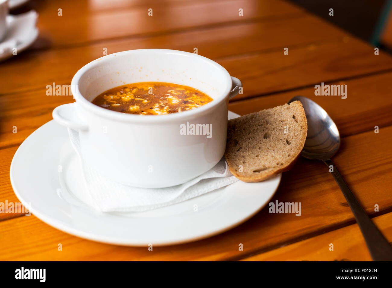 Zuppa di carne in un bianco di ceramica ciotola su una tavola di legno. Mattina illuminazione atmosferica, alla moda locale alla moda soft focus. Foto Stock