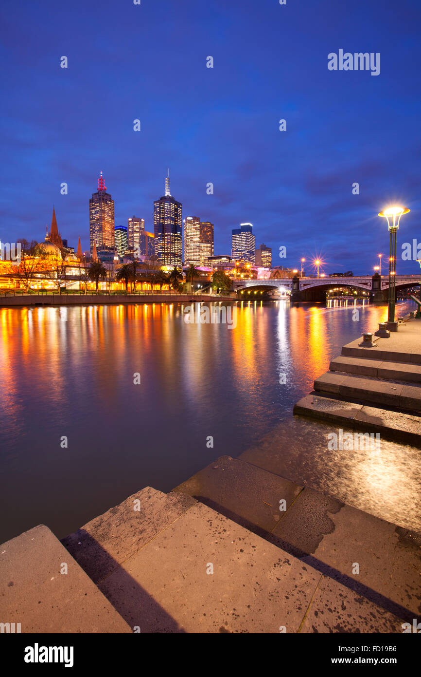 Lo skyline di Melbourne in Australia con la stazione di Flinders Street e i capi da ponte attraverso il fiume Yarra di notte. Foto Stock