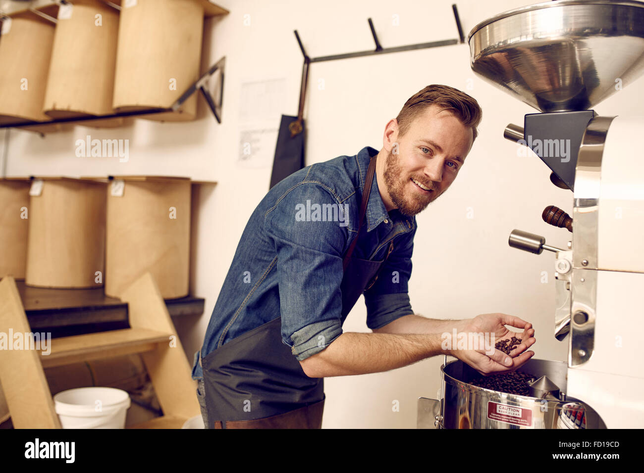 Esperto di caffè fresco di controllo il caffè torrefatto in grani nella moderna ma Foto Stock