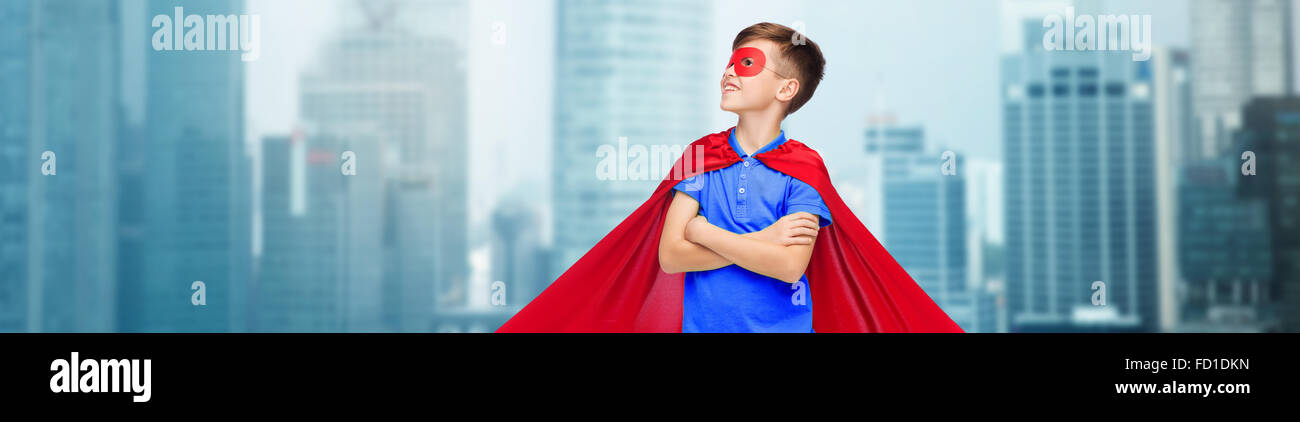 Ragazzo in rosso super hero cape e maschera Foto Stock