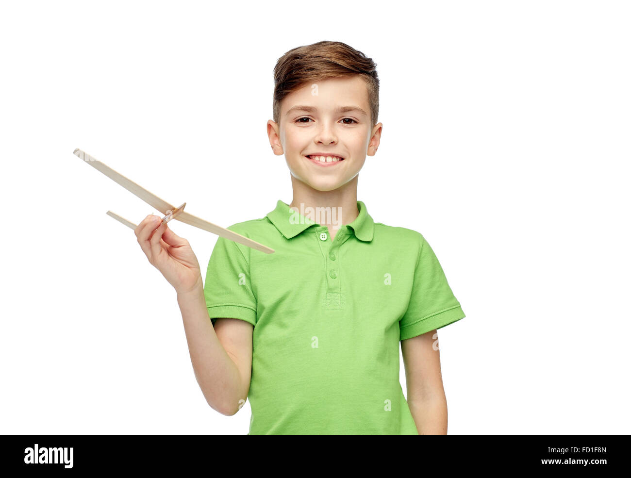 Felice ragazzo in polo verde t-shirt con aeroplano giocattolo Foto Stock