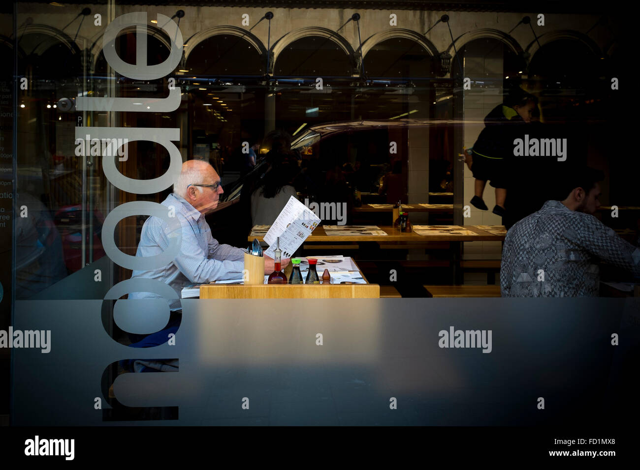 Un uomo anziano guardando un menu in un ristorante, REGNO UNITO Foto Stock