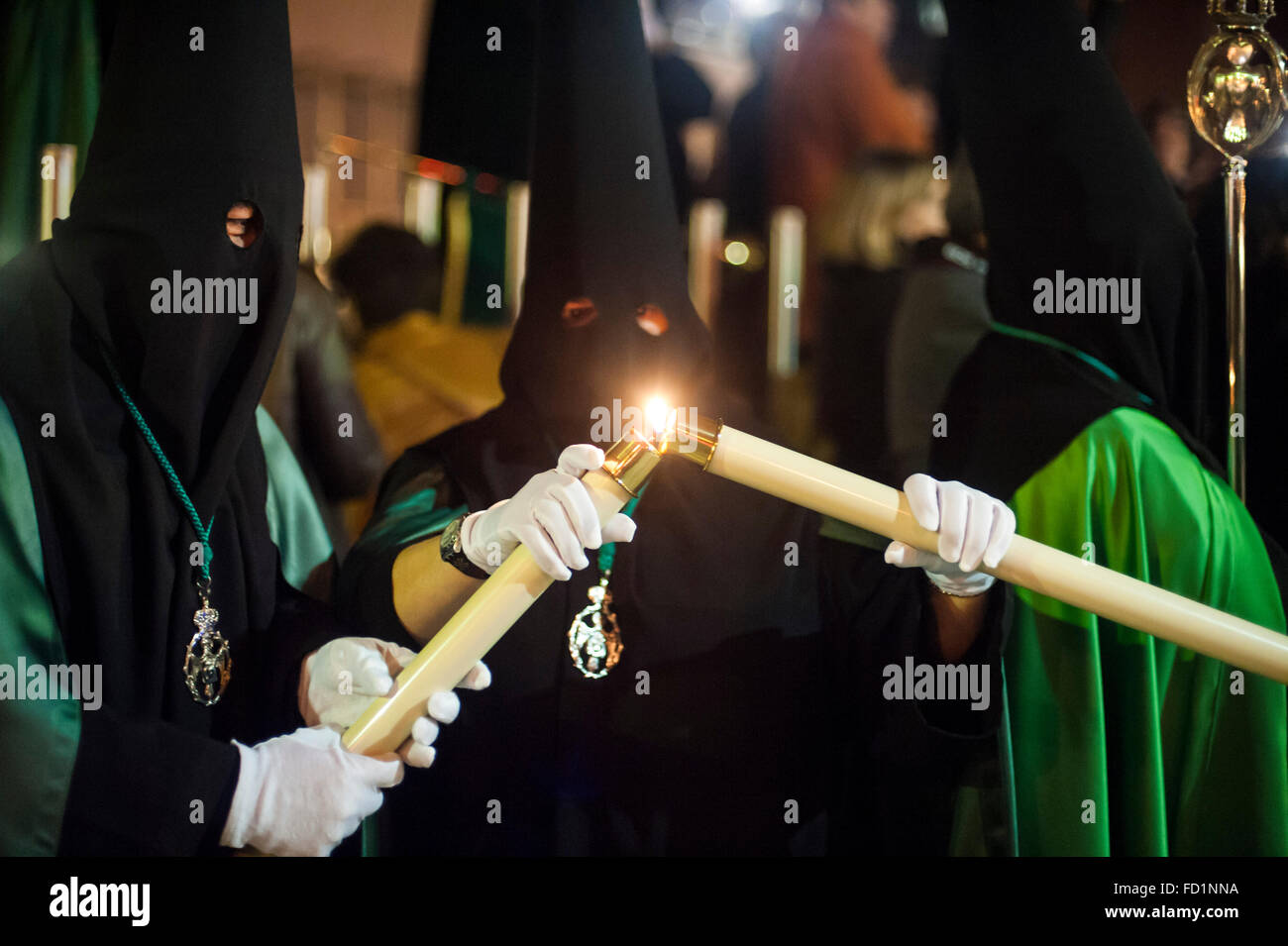 Fratelli della Confraternita di Nostra Signora della Speranza accendendo candele per partecipare alla processione Foto Stock