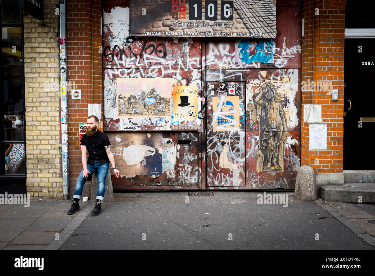 Un giovane maschio con una lunga barba fumatori, London, Regno Unito Foto Stock