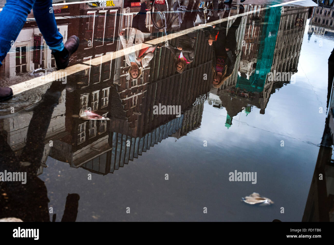 Una strada di Amsterdam si riflette in una pozzanghera dopo la pioggia Foto Stock