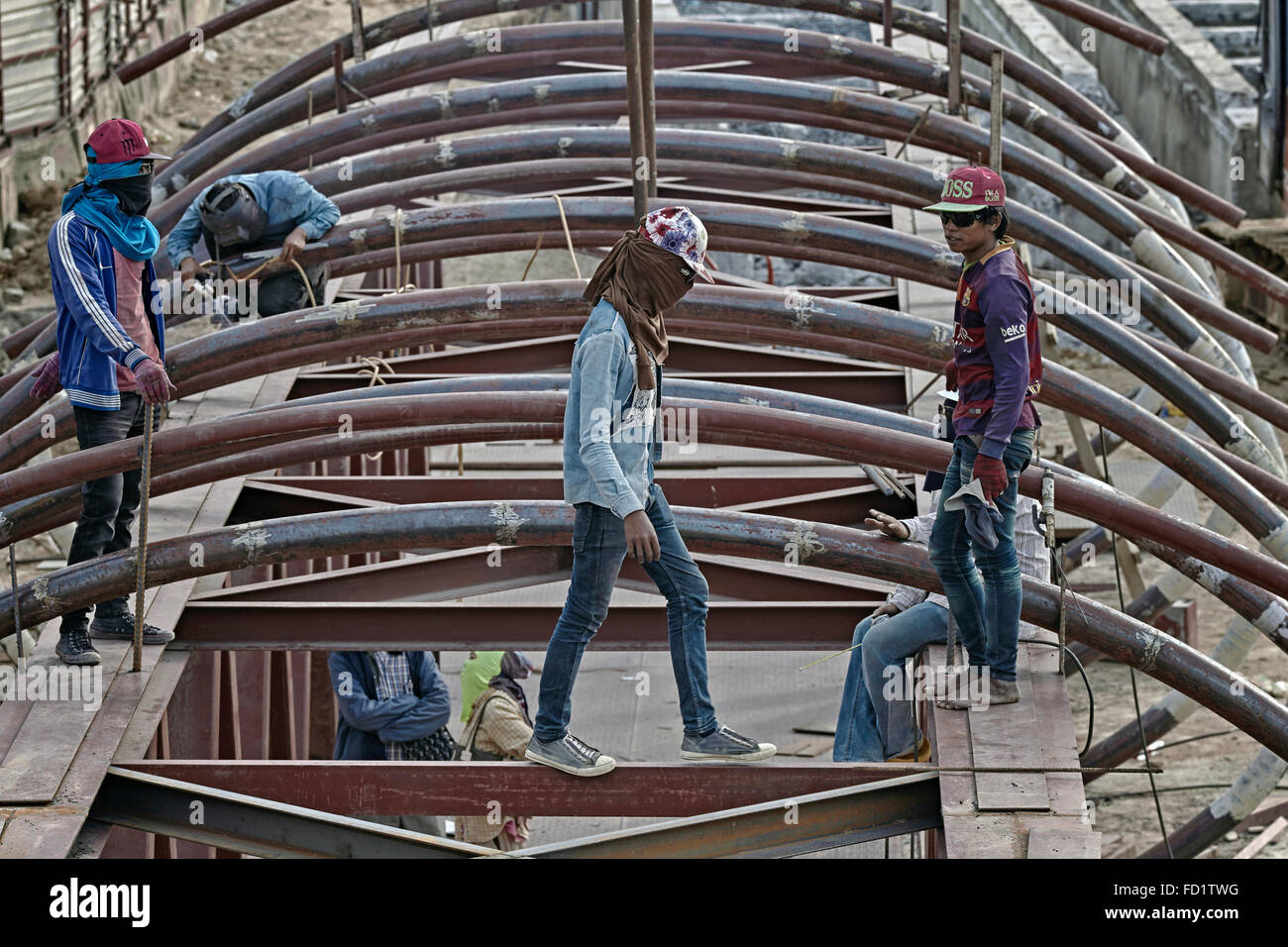 Tailandese Sito di costruzione con i lavoratori a piedi nudi, sneakers e i cappelli da baseball e dimentica i rischi per la salute e la sicurezza. Foto Stock