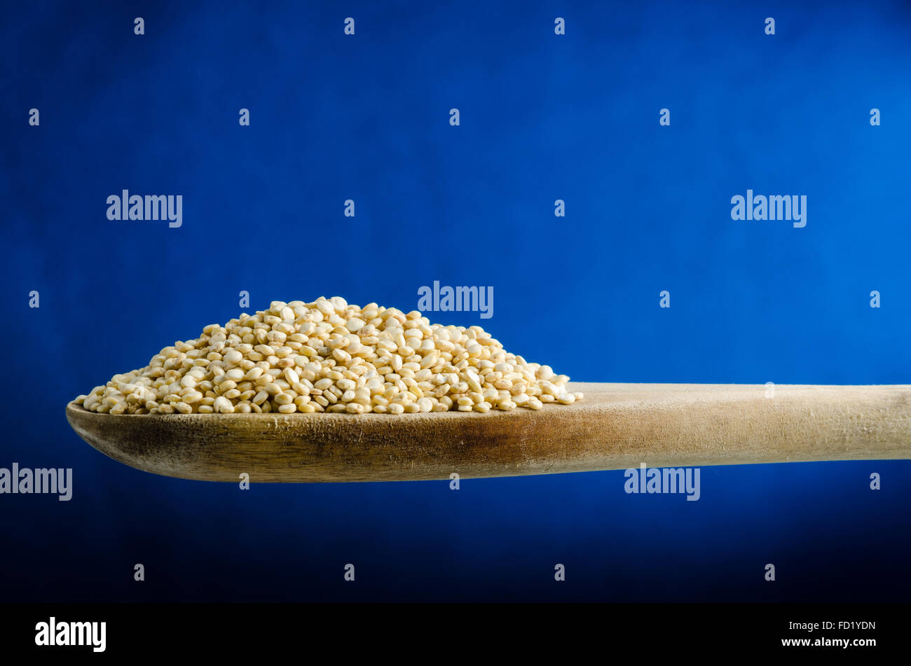 La quinoa in un cucchiaio, vicino, colore di sfondo Foto Stock