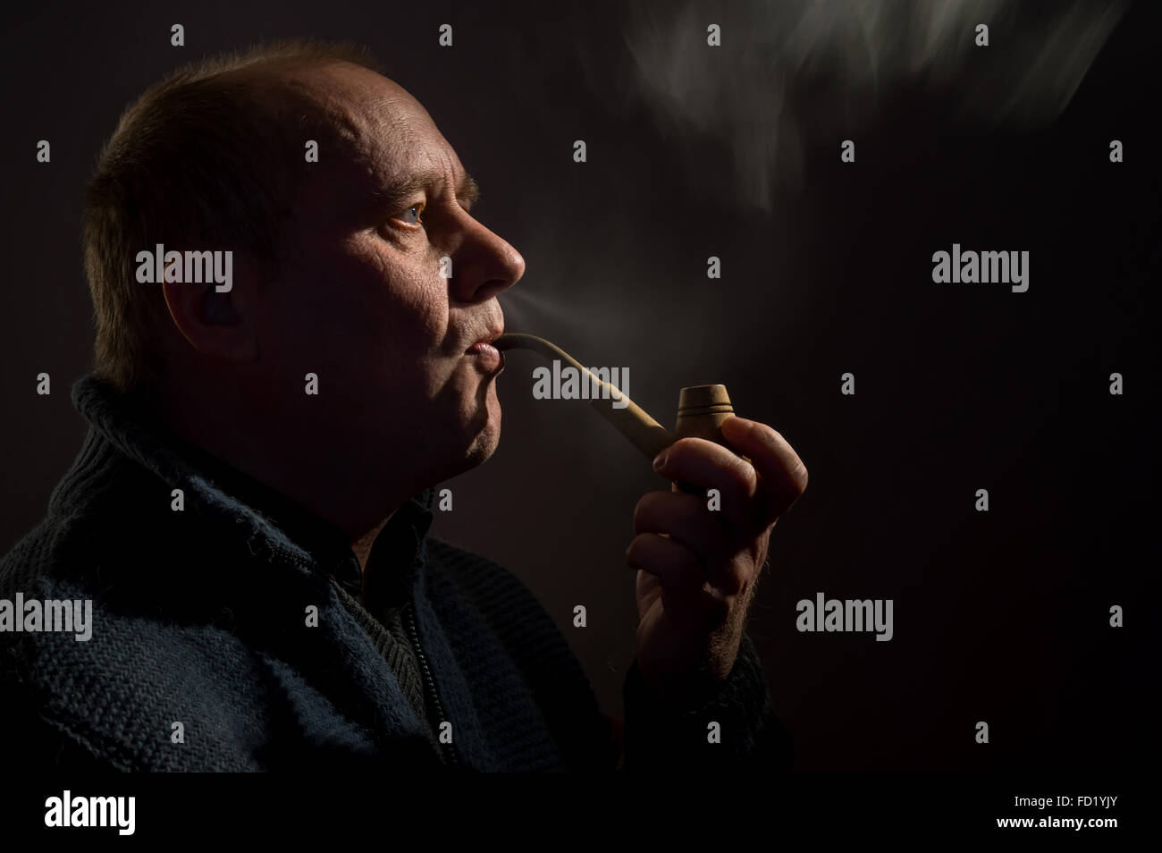Tasto basso ritratto di soggetti di razza caucasica uomo maturo di tabacco da fumo tubo Foto Stock