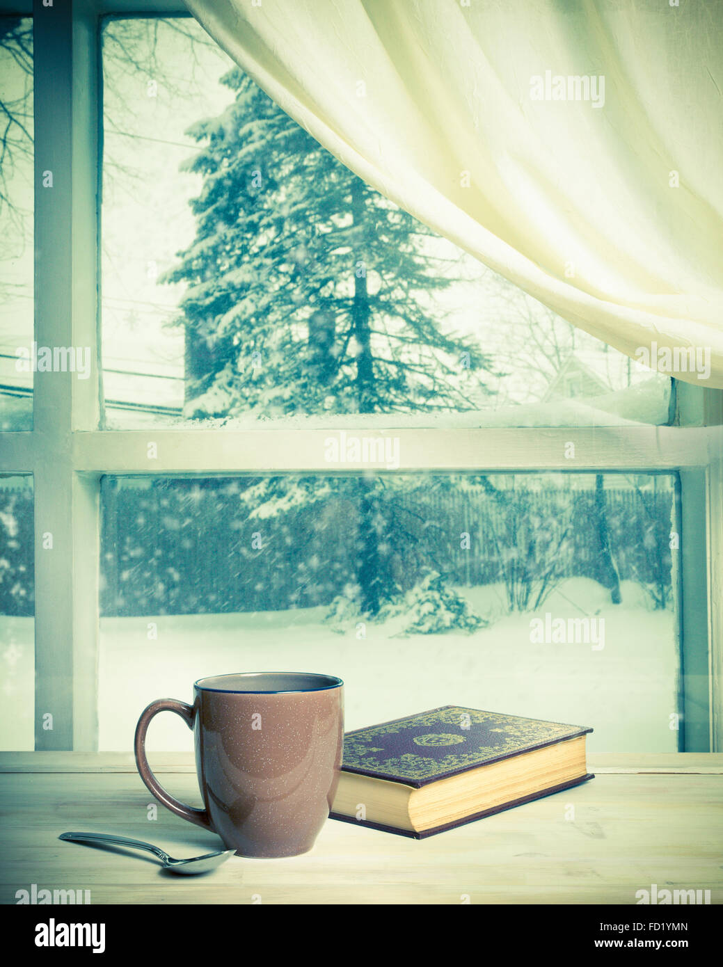 Accogliente casa still-life di tazza di caffè e prenota nuova finestra nevoso dopo la tempesta di neve Foto Stock