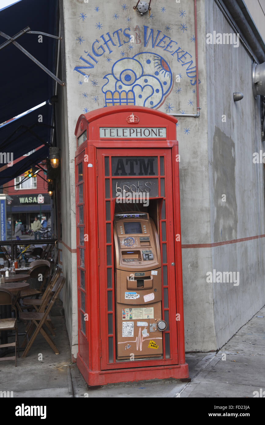 ATM alloggiato in una vecchia cabina telefonica al di fuori di un ristorante a Greenpoint, Brooklyn, New York. Foto Stock