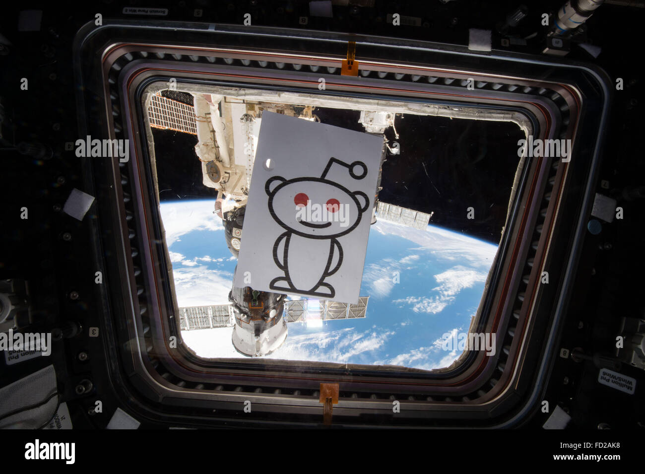 Il logo Reddit pende da una finestra nella Stazione Spaziale Internazionale cupola come astronauta americano Scott Kelly ha condotto il primo NASA Reddit chiedetemi nulla dallo spazio chat Gennaio 24, 2016 in orbita intorno alla terra. Foto Stock