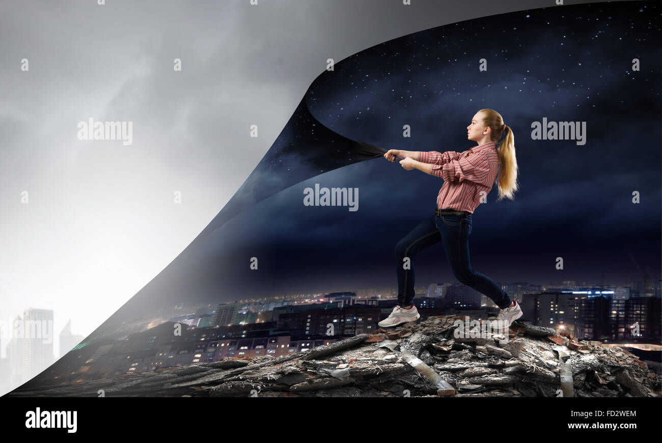 Giovane donna tirando pagina per modificare la scena Foto Stock