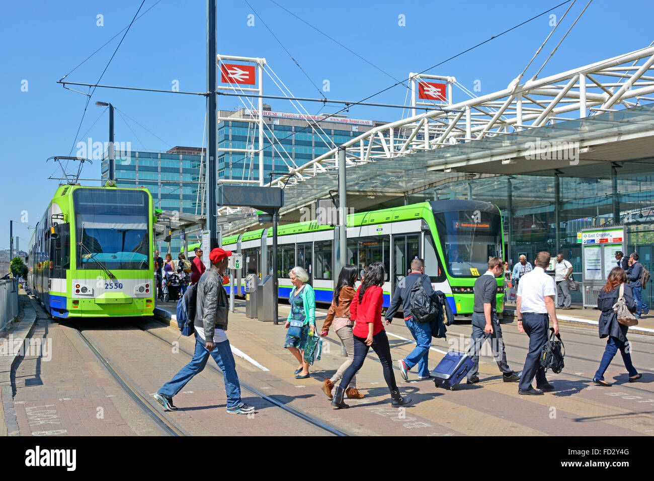 La gente di scena di strada sull'attraversamento pedonale sopra le piste del tram a. East Croydon British Rail interscambio stazione ferroviaria servizio tramlink in attesa Inghilterra Regno Unito Foto Stock