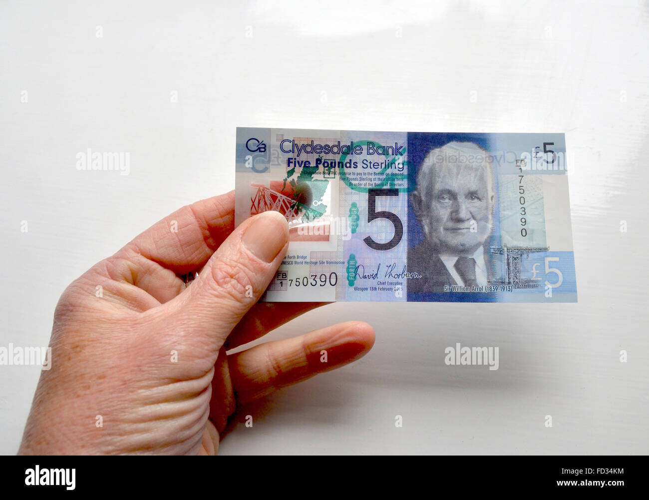 Una nuova banca di Clydesdale, 5 pound nota tenuto in una mano e rivelando una sezione di plastica trasparente la natura. Foto Stock