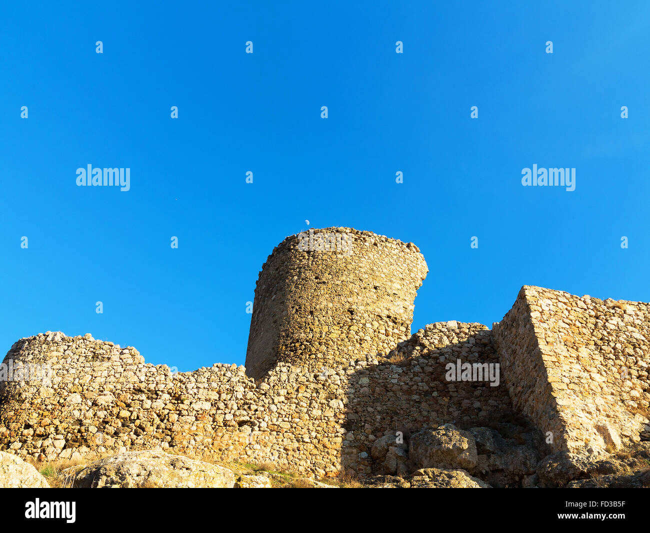 Le fatiscenti rovine della vecchia fortezza sulla sommità dei monti della Crimea in condizioni di luce solare intensa contrasto contro lo sfondo di co Foto Stock