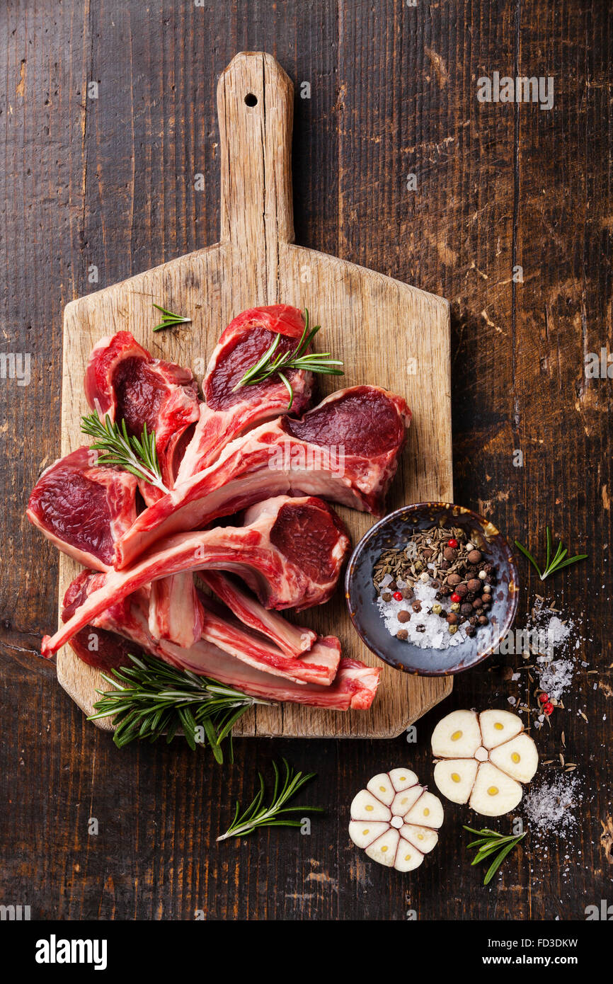 Crudo fresco di carne di agnello nervature e condimenti scuro su sfondo di legno Foto Stock