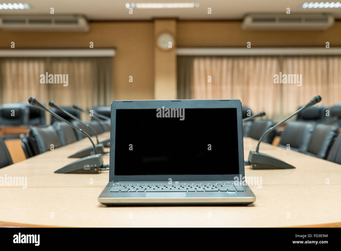 Prima di una conferenza,portatile nella parte anteriore delle sedie vuote in sala conferenze Foto Stock