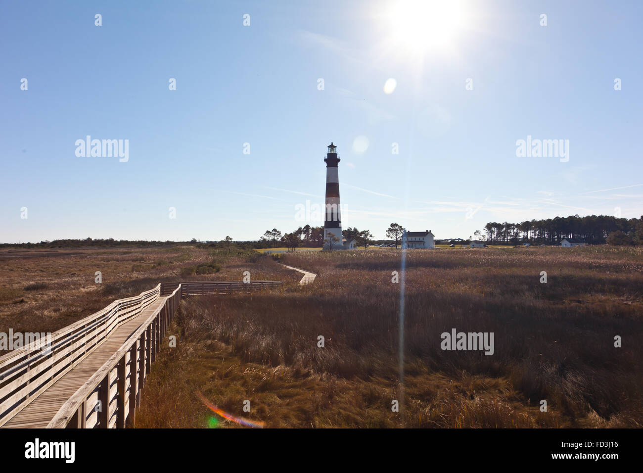 Guardando il Bodie Island Lighthouse vicino a Nag Testa, North Carolina dal lungomare con una raffica di sole dietro Foto Stock