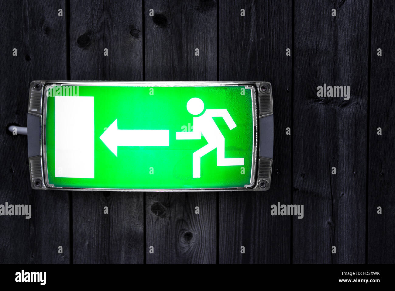 Uscita di emergenza segno su tavola in legno parete Foto Stock