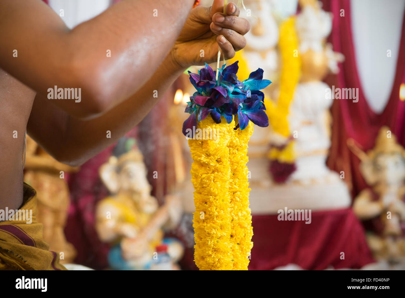 Tie up ghirlanda di fiori. La tradizione indiana indù ear piercing cerimonia. India offerte rituali. Foto Stock