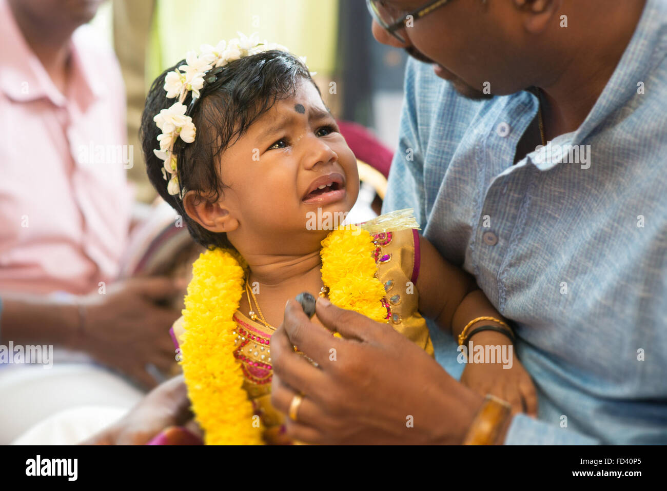 Baby girl preparato per la karnvedh eventi. La tradizione indiana indù ear piercing cerimonia. India offerte rituali. Foto Stock