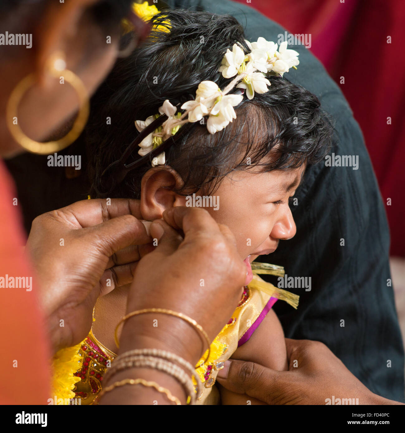 Indiana tradizionale famiglia indù avente ear piercing cerimonia bambina di un anno di età. Foto Stock