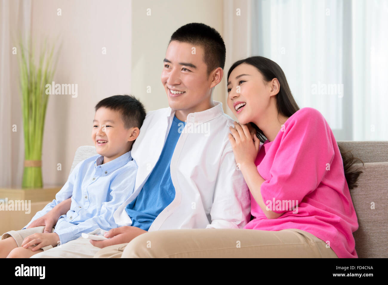 Famiglia giovane di guardare la TV Foto Stock